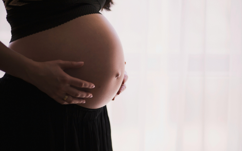 おなかに手を添える妊娠中の女性